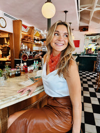 Burnt orange Texas game day chiffon scarf worn at restaurant in Austin